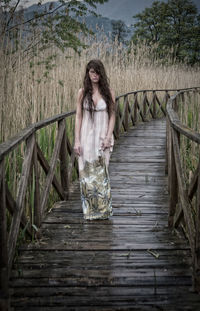 Full length of woman standing on footbridge