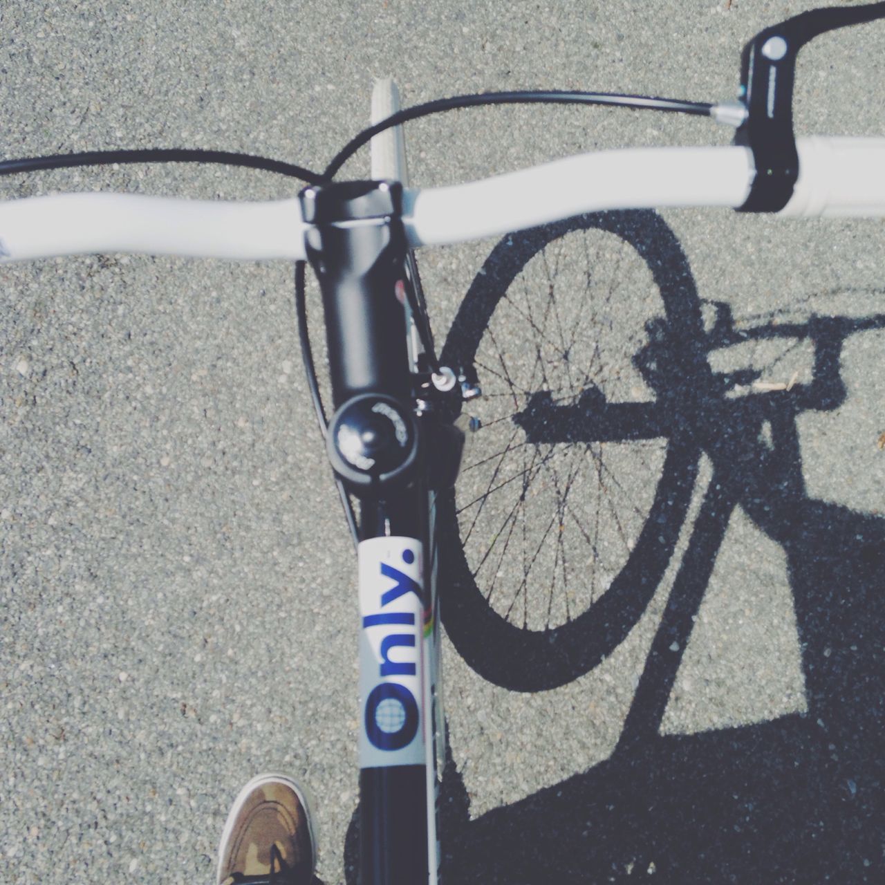 bicycle, transportation, land vehicle, mode of transport, street, road, high angle view, low section, part of, cycling, riding, shadow, cropped, road marking, wheel, person, asphalt