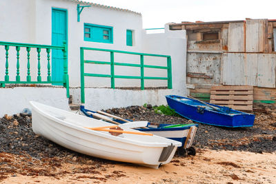 Boats moored on shore against buildings