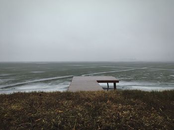 Pier on beach against sky