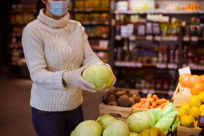 Midsection of man holding ice cream at market