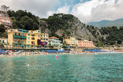 Scenic view of sea by buildings against sky