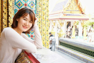 Portrait of smiling girl sitting outdoors