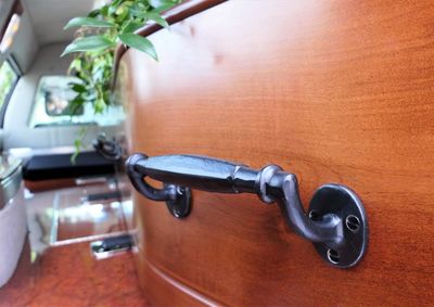 Closeup shot of a funeral casket or coffin in a hearse or chapel or burial at cemetery
