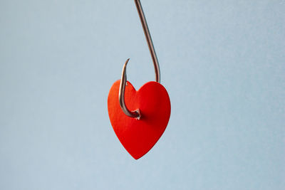 Close-up of red heart shape decoration hanging against clear sky