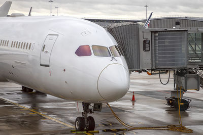 Airplane on airport runway against sky