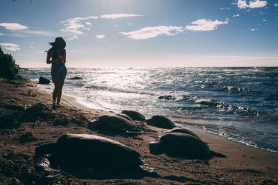 Full length of woman walking at beach against sky