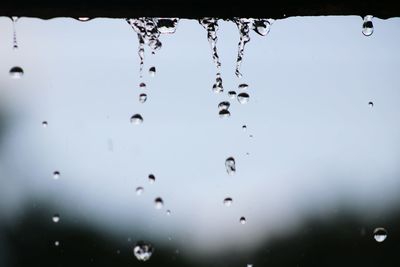 Close-up of waterdrops on water against sky