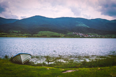 Scenic view of lake by mountains against sky