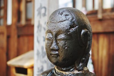 Close-up of buddha statue against building