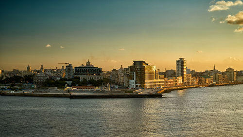 View of buildings at waterfront during sunset