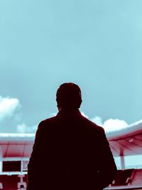 Rear view of silhouette man standing against sky