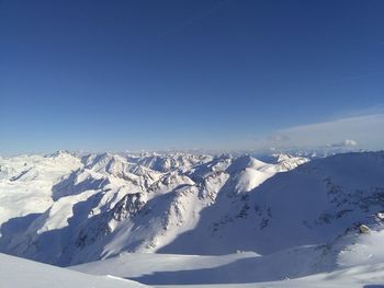 Scenic view of snowcapped mountains against clear blue sky