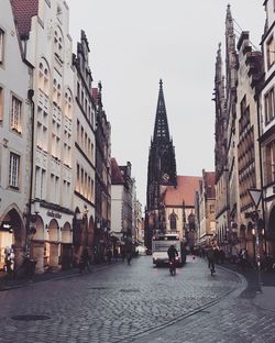 People on street in city against sky