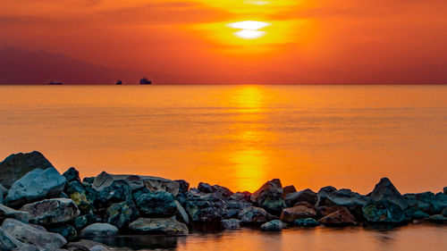 Scenic view of sea against orange sky