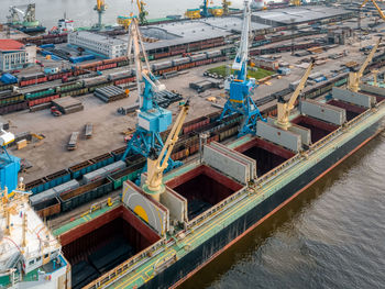 Port with boats, cranes and buildings. port cranes load various cargoes into the hold of the ship.