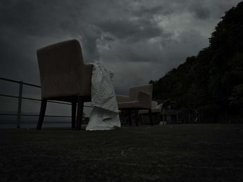 Rear view of woman standing on seat against sky