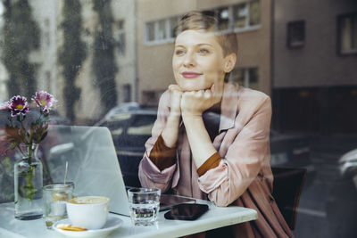 Woman with her laptop enjoying the view in a cafe