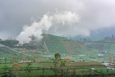 A volcanic sulphur plant releases smoke over dieng agricultural plateau in central java, indonesia