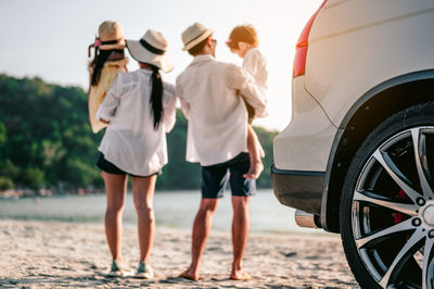 Rear view of people standing on beach