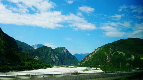Road by mountains against sky