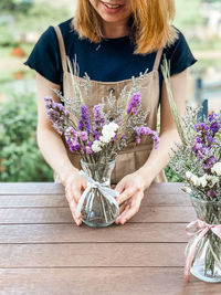 Midsection of woman holding purple flower