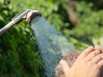 Close-up of man taking shower outdoors