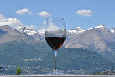 Close-up of beer in mountains against sky