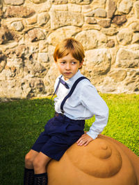 Boy looking away while sitting at park