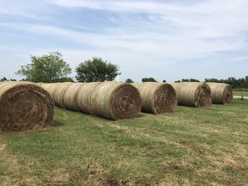 Hay bales on field against sky