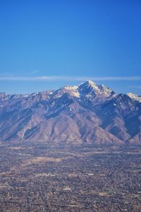 Scenic view of mountain range against blue sky