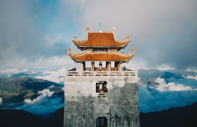 View of temple building against cloudy sky