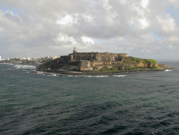 Buildings by sea against sky