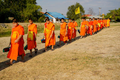 Rear view of people walking on footpath