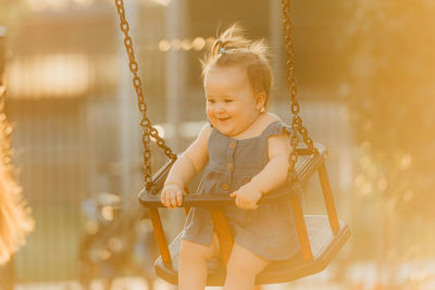 Portrait of boy swinging at playground