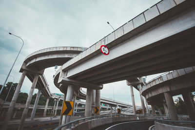 Bridges in city against cloudy sky