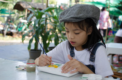 Close-up of girl making paintings on table