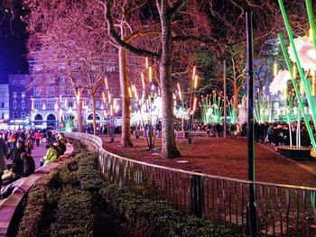 People in illuminated city at night
