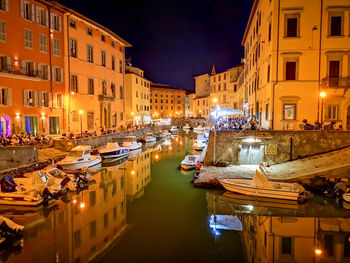 High angle view of illuminated canals reflecting buildings in livorno city at night