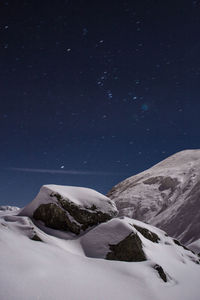 Scenic view of snowcapped mountains against sky at night