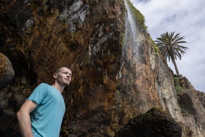 Man standing under waterfall in tenerife, canary island, spain.