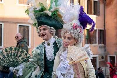 Happy friends in traditional clothing outdoors