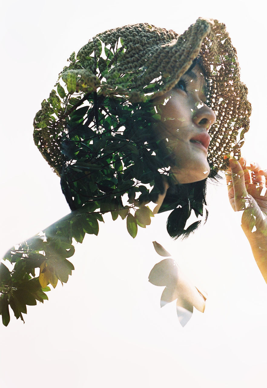 CLOSE-UP PORTRAIT OF YOUNG WOMAN WITH LEAVES