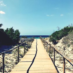Footpath by sea against sky
