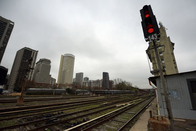 Railroad tracks amidst buildings in city against sky