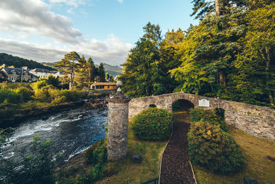 Arch bridge over river against sky