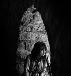 Woman looking away against wall in building