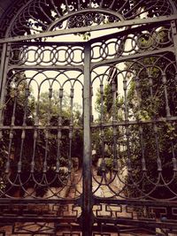 Low angle view of metal gate against sky