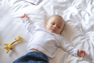 High angle view of baby lying on bed