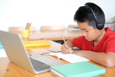 Asian boy student studying learning lesson online. remote meeting distance education at home